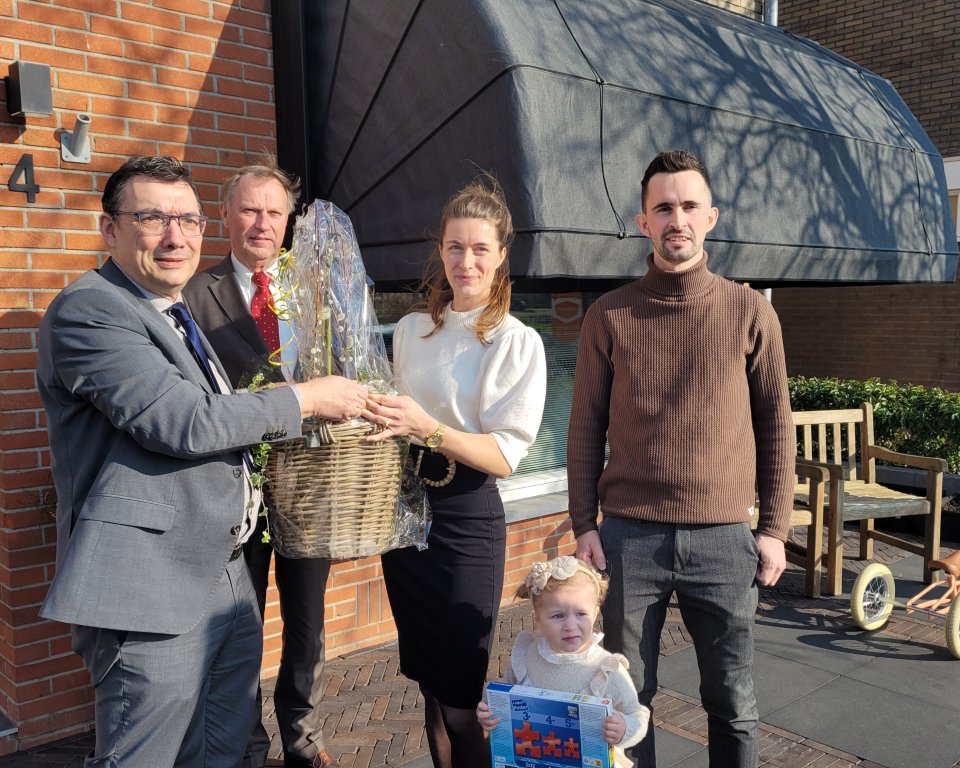 Een foto van wethouder Willem Foppen waarbij hij de winnaars van het duurzaamste huis van Flevoland hun Prijs overhandigd