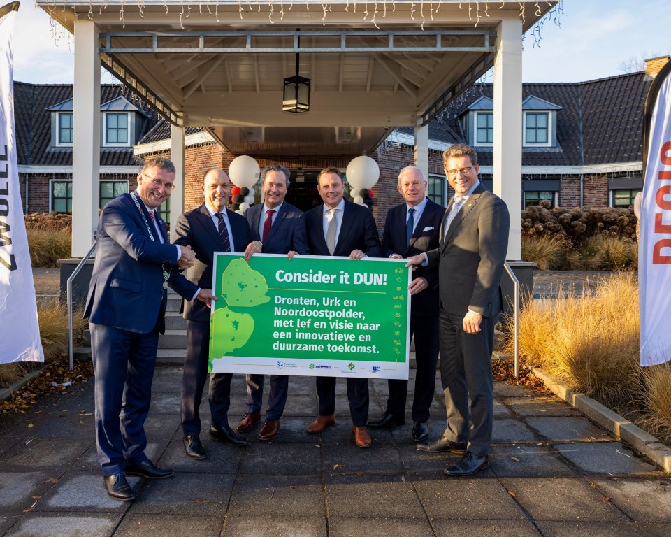 Op de foto zie je: Bart Jaspers Faijer (burgemeester Urk) Peter Snijders (burgemeester Zwolle, voorzitter Regio Zwolle) Toon van Dijk (gedeputeerde provincie Flevoland) Siert Jan Lap (locoburgemeester Dronten, vervangt burgemeester Jean Paul Gebben) Arjen Gerritsen (commissaris van de Koning in Flevoland) Roger de Groot (burgemeester Noordoostpolder) houden een bord vast met de ondertekening. 