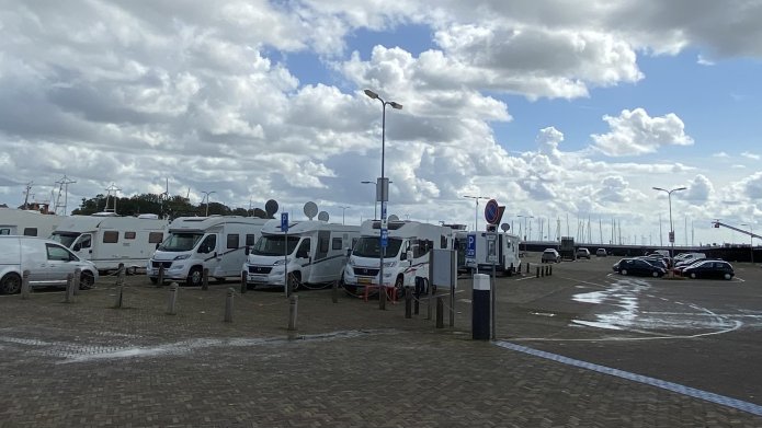 Campers op het haventerrein van Urk met veel wolken in een blauwe lucht
