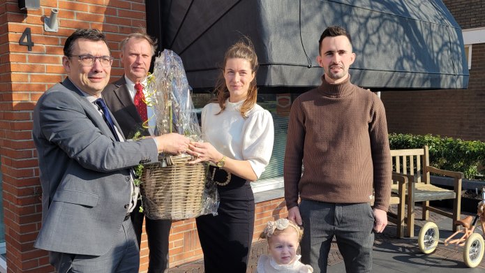 Een foto van wethouder Willem Foppen waarbij hij de winnaars van het duurzaamste huis van Flevoland hun Prijs overhandigd