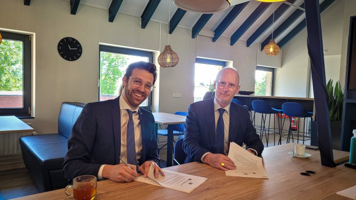 Op de foto is wethouder Nathanaël Middelkoop en de heer Pieter van Slooten te zien terwijl ze de bouwrealisatie overeenkomst ondertekenen