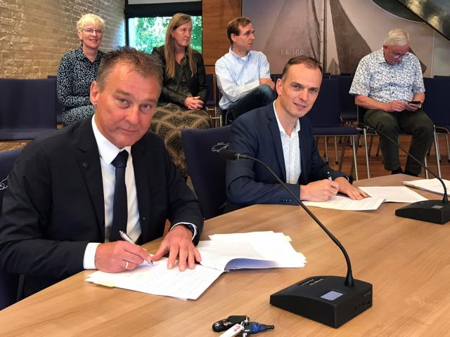 Wethouder Freek Brouwer (gemeente Urk) en wethouder Anjo Simonse van de gemeente Noordoostpolder ondertekenen de contracten voor de ambulante jeugdhulp