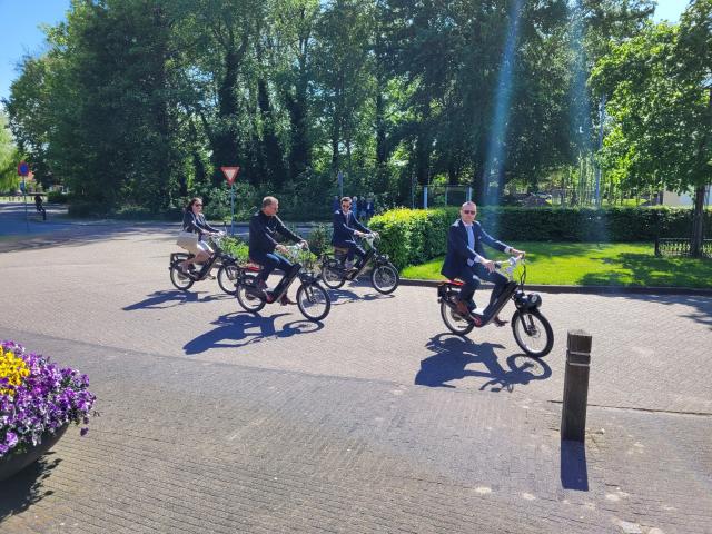 Wethouder Gerrit Post met collega-wethouders en zijn vrouw op de e-scooter tijdens zijn afscheid