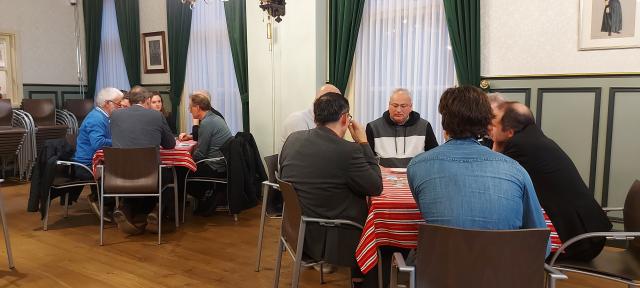 Groepjes mensen aan tafel in gesprek