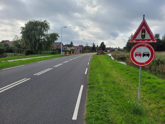 Deel Staartweg met verkeersborden verboden in de halen en pas op, verkeerslichten