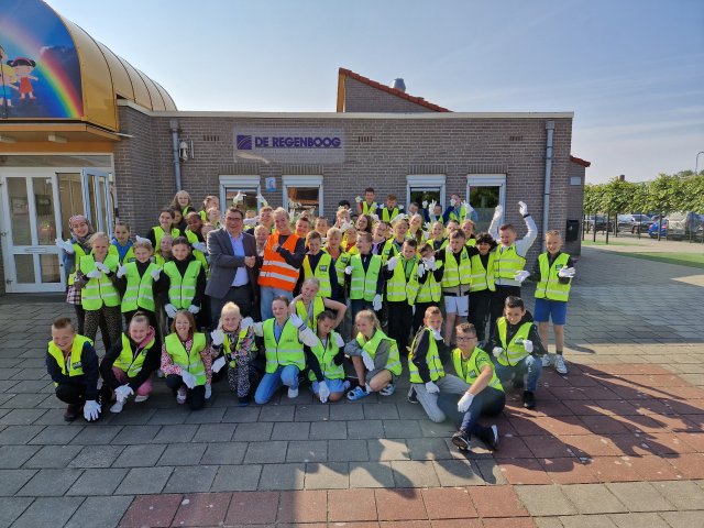 Leerlingen van de Basisschool De Regenboog voor schoolgebouw, samen met Willem Foppen