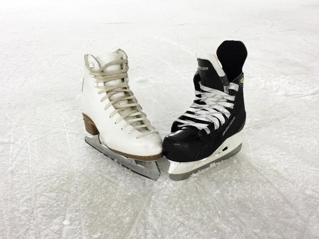 Een kunstschaats en een hockeyschaats staan op ijs
