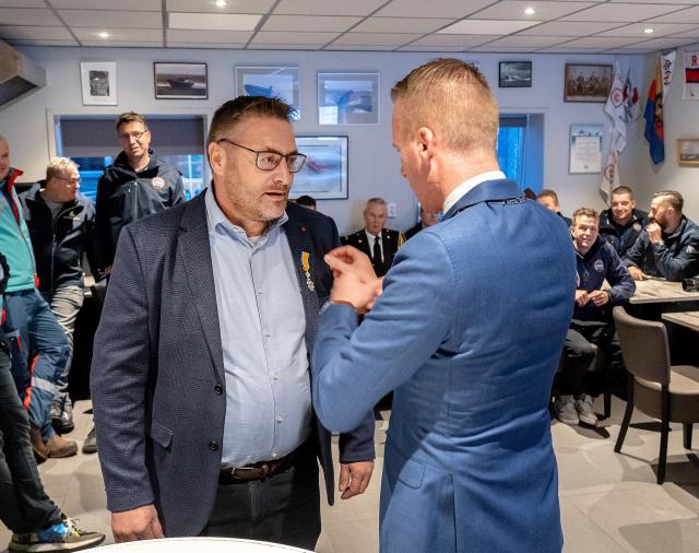 Burgemeester Cees van den Bos spelt de Koninklijke onderscheiding op bij Dirk Korf