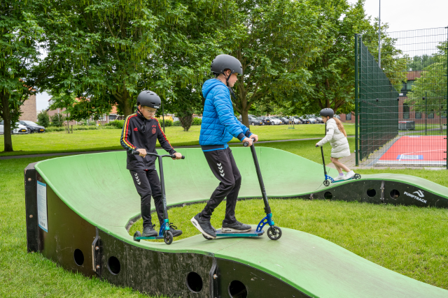 Kinderen op een step, pumptrackbaan