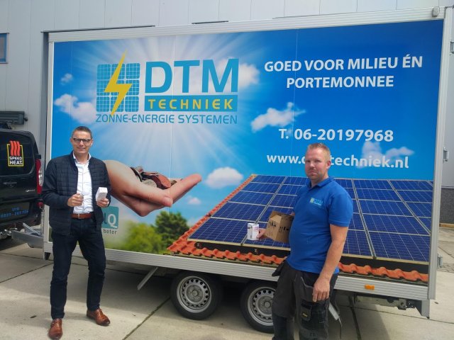Wethouder Gerrit Post en Teun Woord van DTM Techniek tonen de led-lamp die weggegeven wordt tijdens de campagne "Energie besparen doen we samen".
