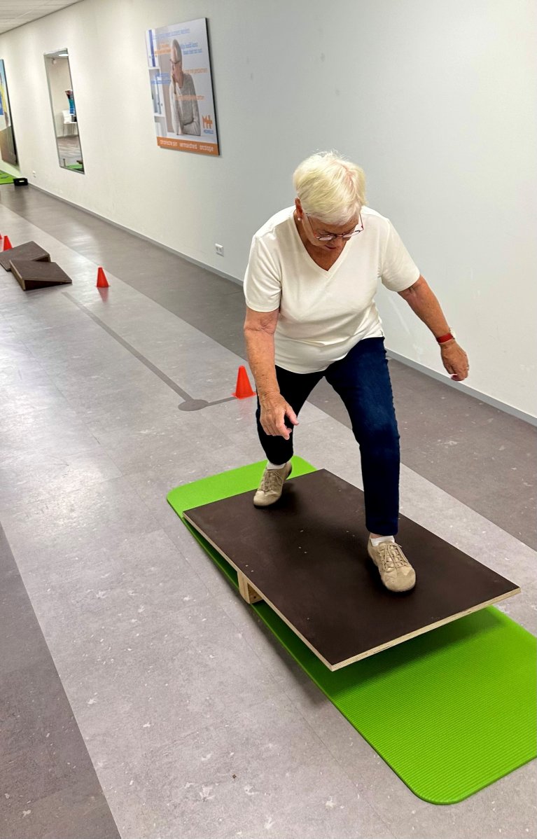 Vrouw doet balans oefening op beweegbare plank