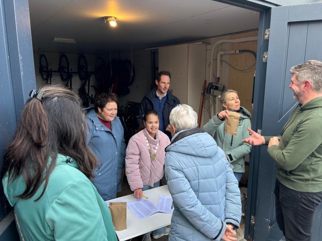 Vrijwilligers en wethouder Bram Bots delen gratis bloemzaad uit.