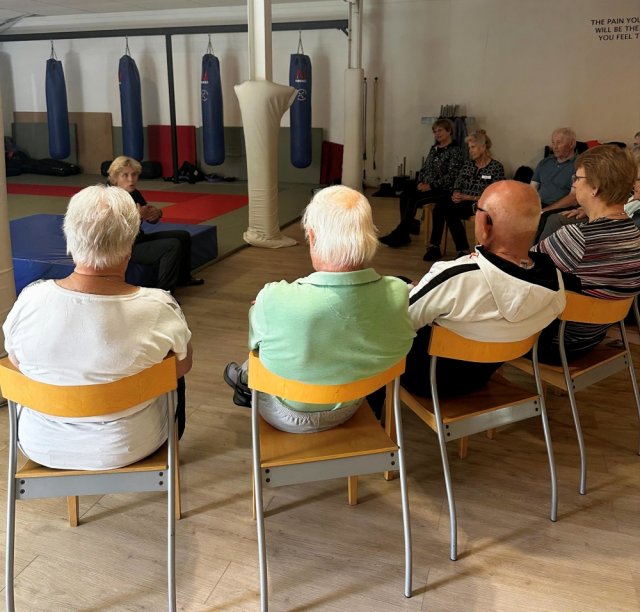 Groep deelnemers toont aandacht tijdens een voorgaande bijeenkomst.