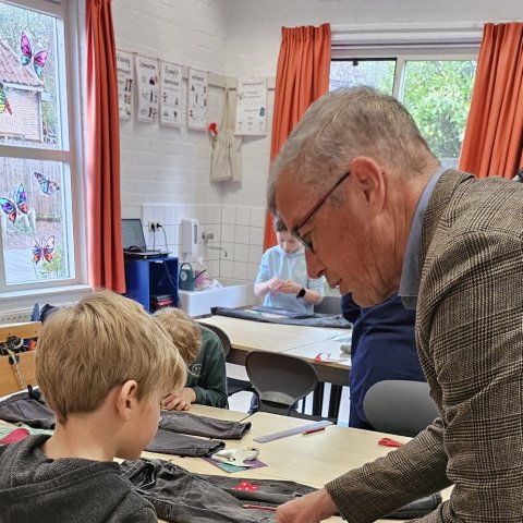 Wethouder De Jonge helpt mee met het opknappen van kleding