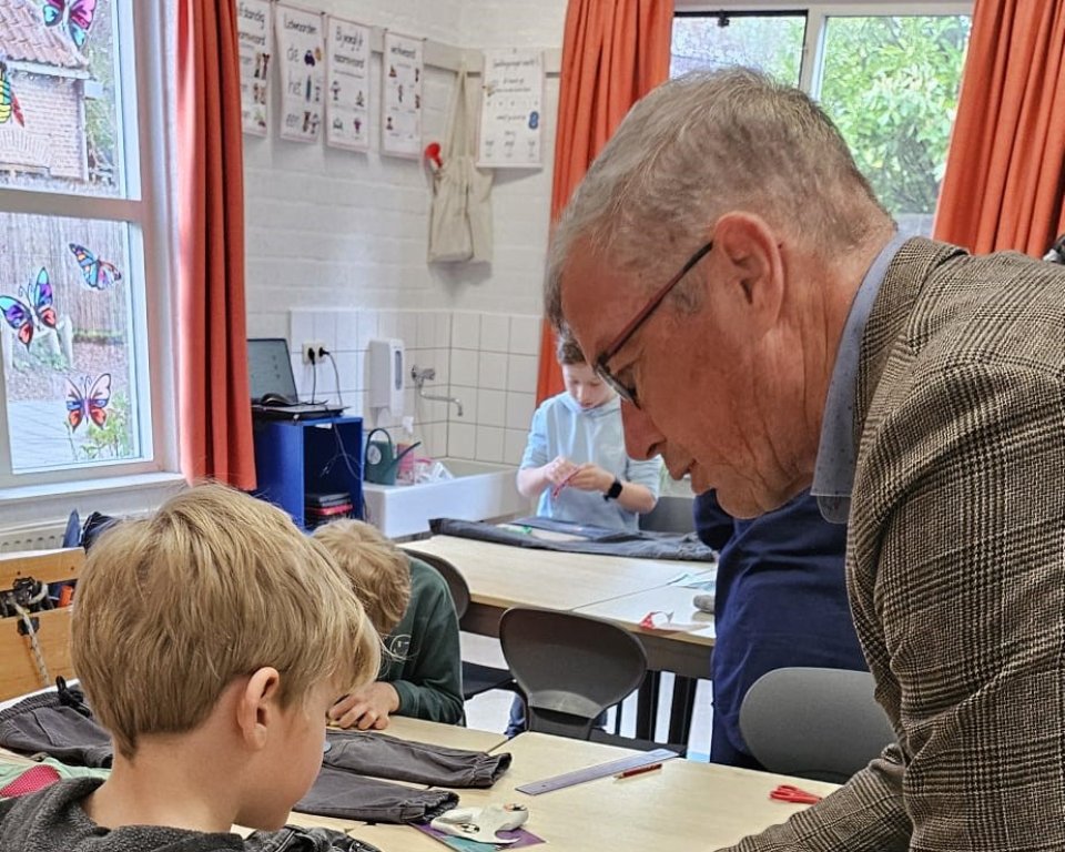 Wethouder De Jonge helpt mee met het opknappen van kleding