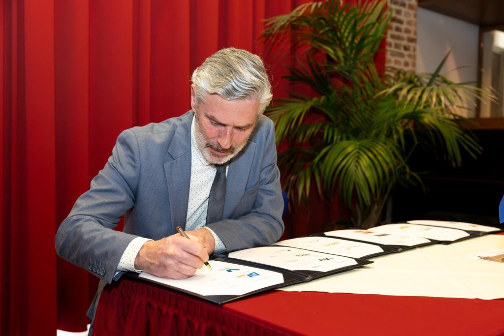 Wethouder Smeets die zijn handtekening zet