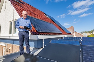 Man op een dak met zonnepanelen