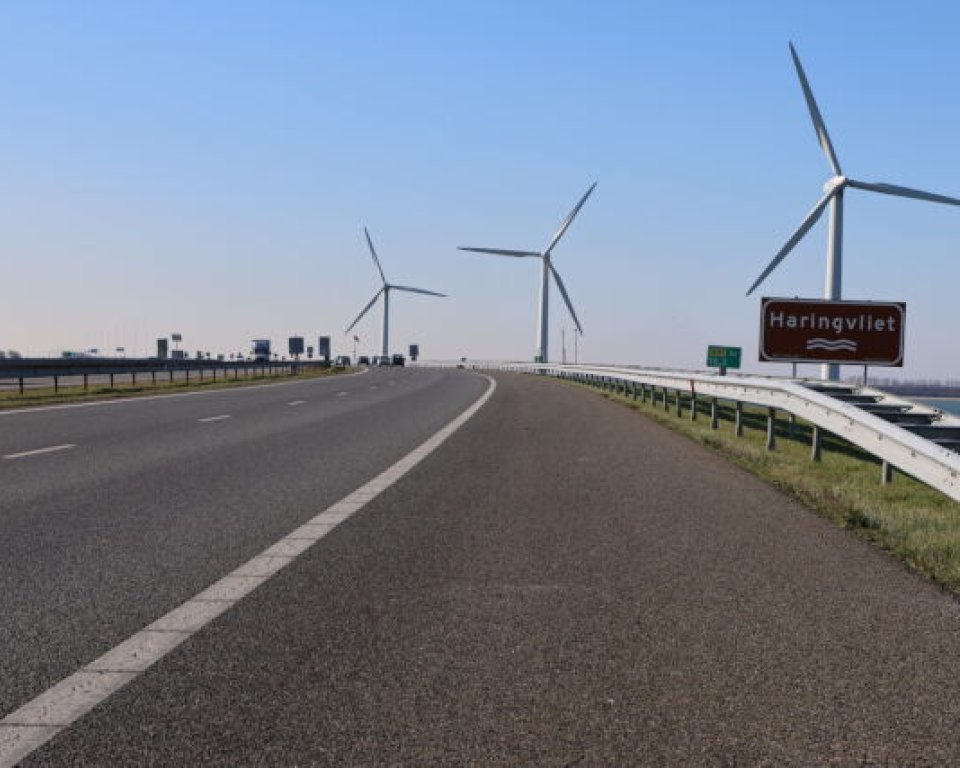 Wegdek Haringvlietdam op de achtergrond windmolens