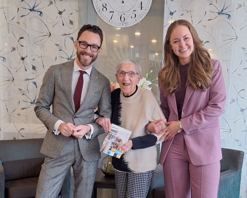 Overhandiging eerste exemplaar brochure Veilig en Vitaal in Voorne aan Zee door burgemeester Arno Scheepers en raadslid Melissa de Rijke aan mevrouw Scharloo 