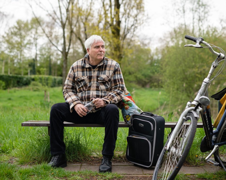 Man op bankje in het park