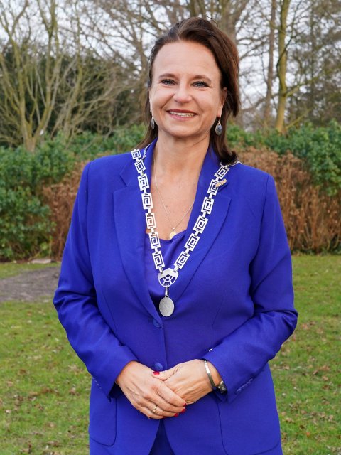 De burgemeester in koningsblauw pak in het park