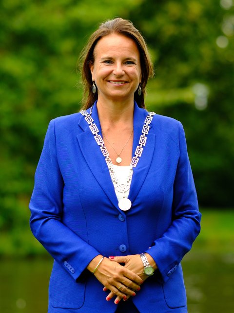 De burgemeester in koningsblauw pak in het park