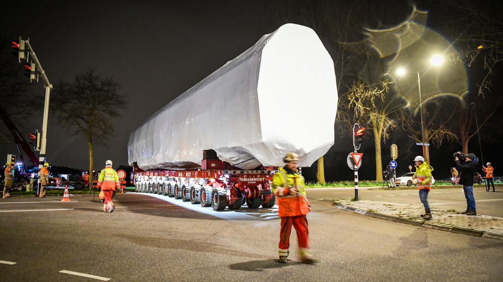 Een SPMT met treinstel steekt de weg over