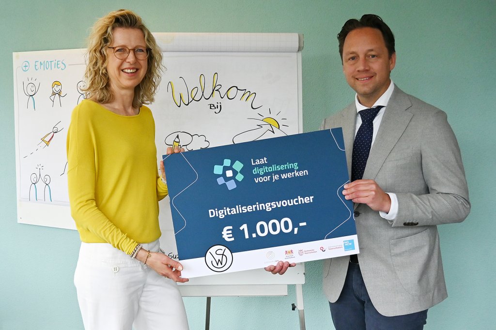 Wethouder Paul de Bruijn toont een levensgrote voucher
