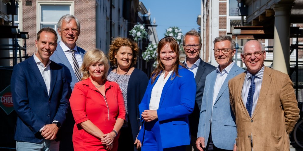 Groepsfoto van de acht ondertekenaars