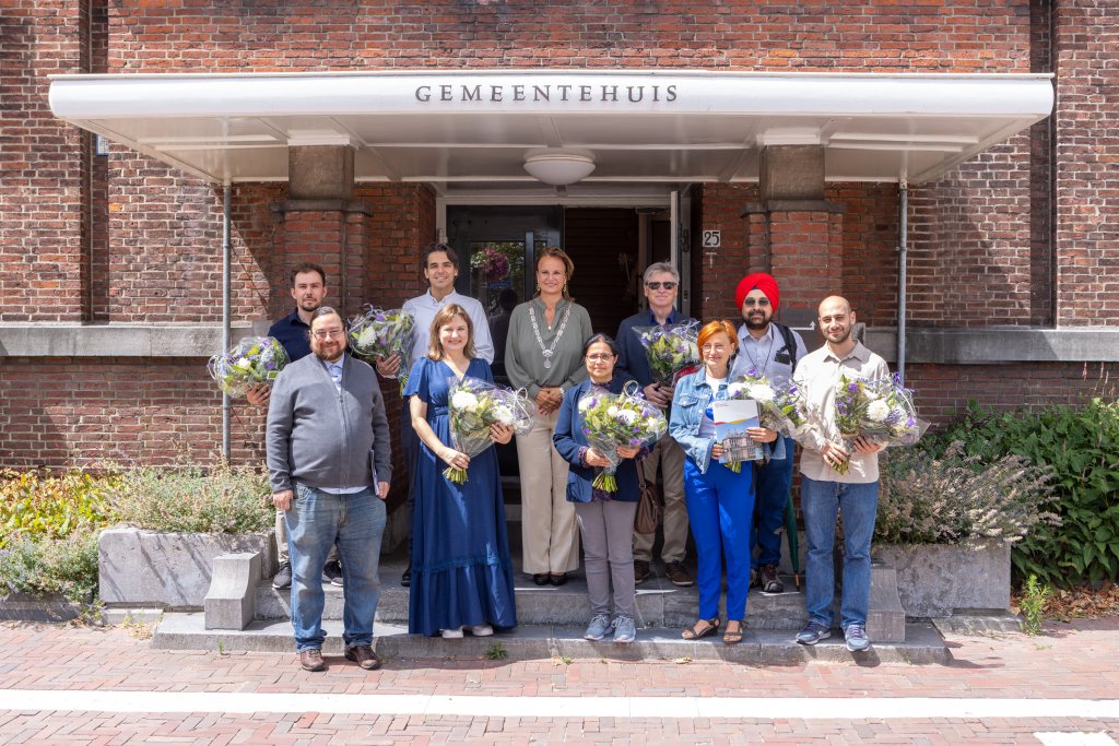 De kandidaten en de burgemeester poseren voor het gemeentehuis