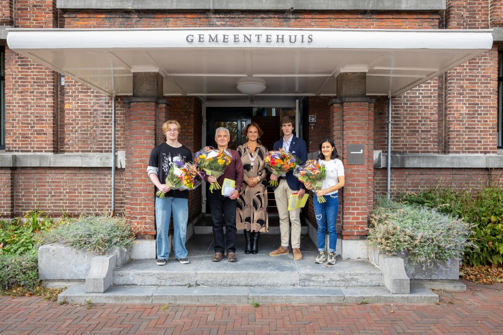 De kandidaten en de burgemeester poseren voor het gemeentehuis
