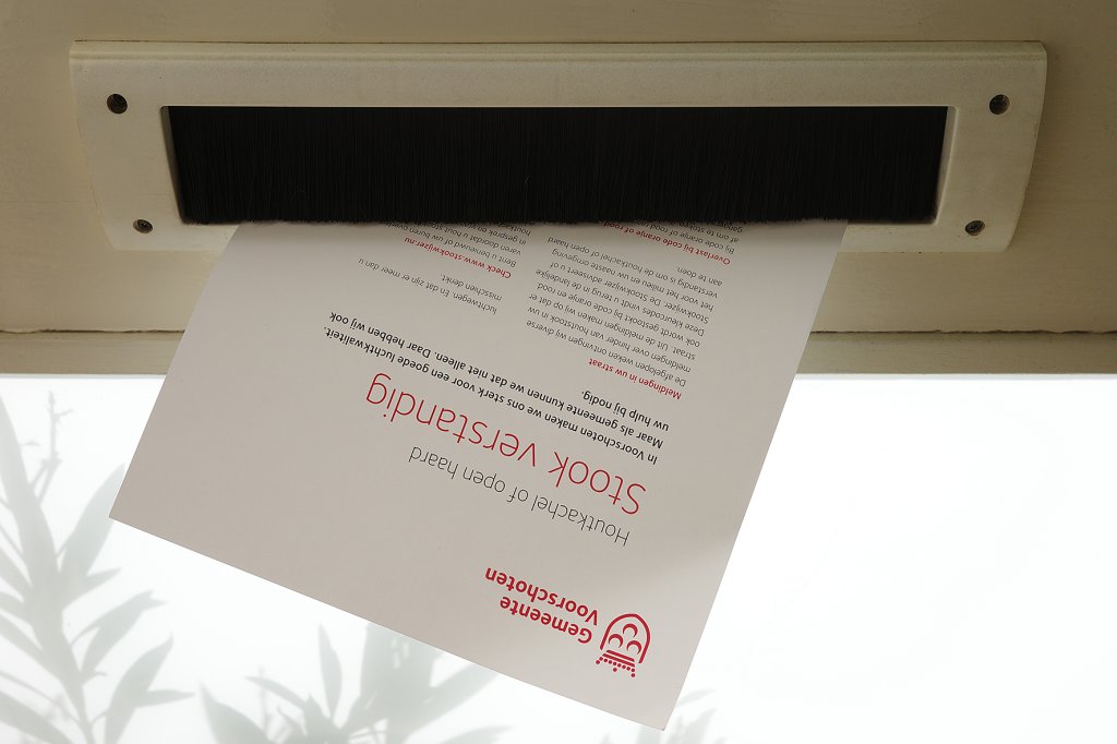 Een flyer steekt uit een brievenbus