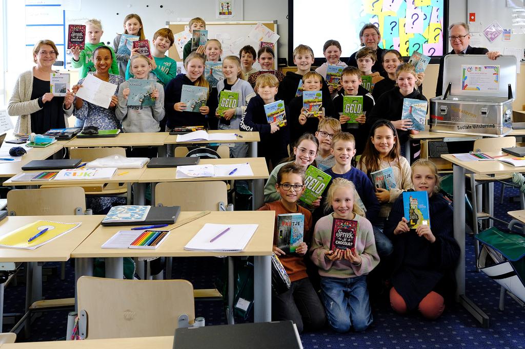 Leerlingen poseren met boeken uit de leskist