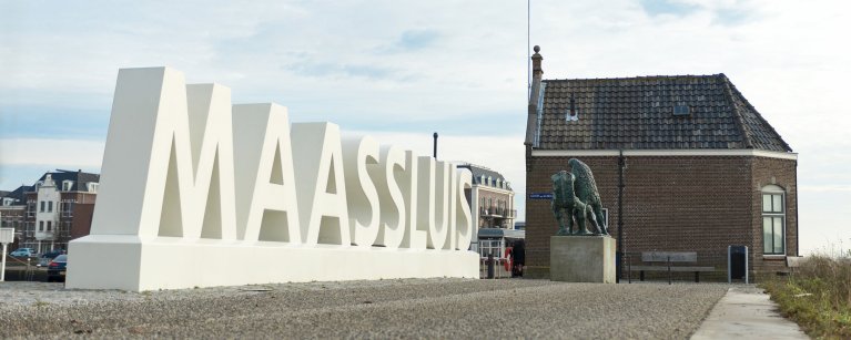 Grote witte letters MAASSLUIS aan de waterkant