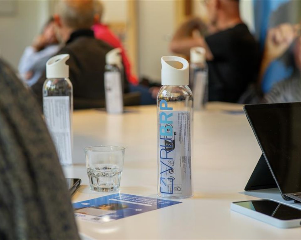 Fles met vrijBRP logo op bureau
