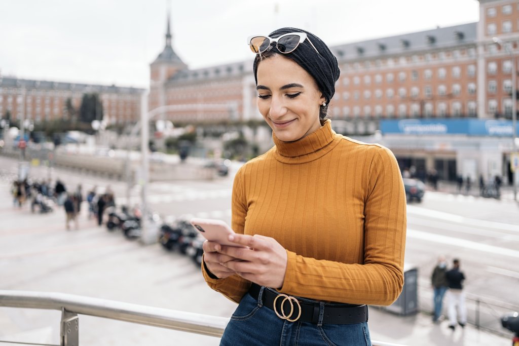 Vrouw kijkt blij naar telefoon