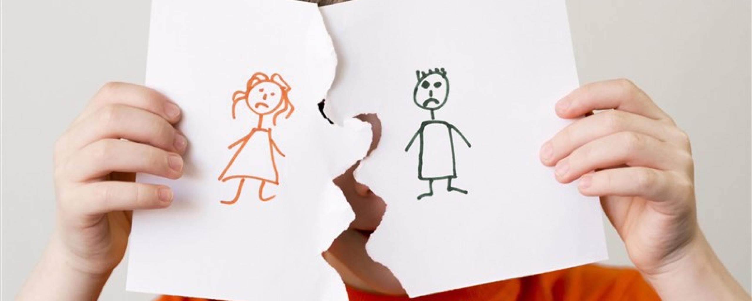 jongen met symbolisch verscheurde tekening van ouders