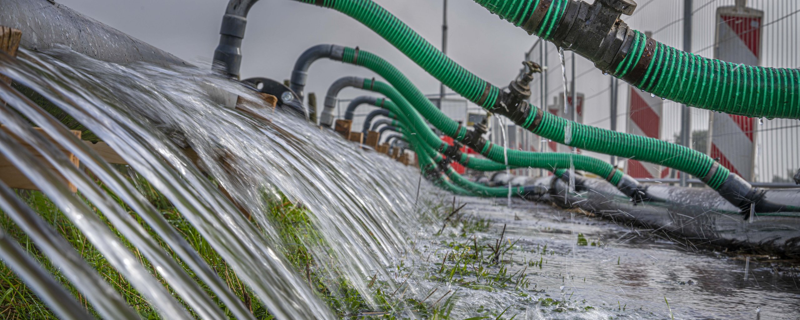 Water stroomt over de dijk. 