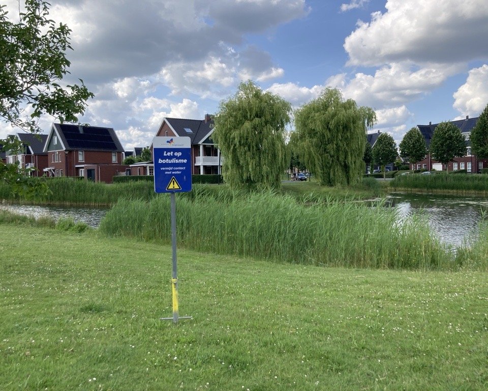 Bord met 'let op, blauwalg' bij een vijver in Huissen
