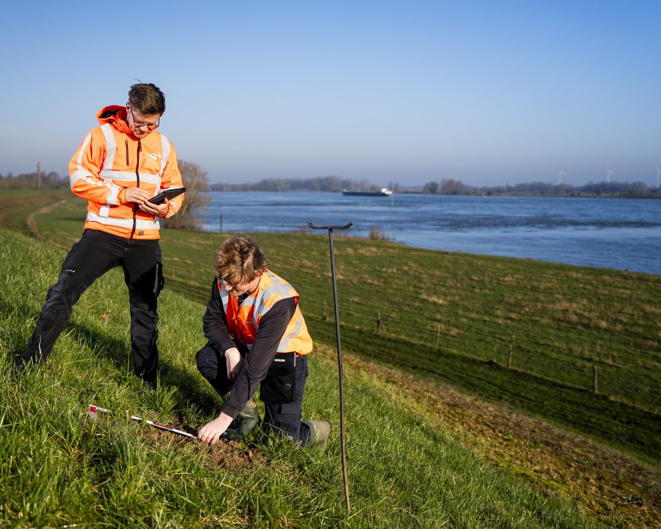 Medewerkers inspecteren de dijk