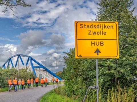 Belangstellenden wandelen over de dijk 