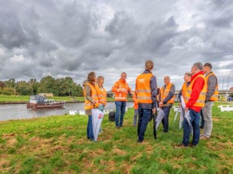 Een groep belangstellenden krijgt uitleg over de werkzaamheden aan de dijk