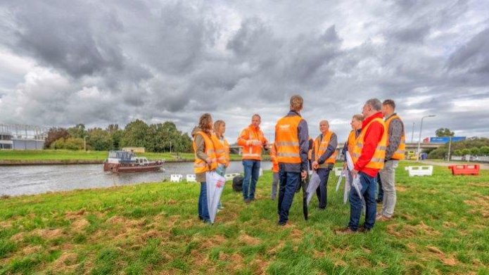 Een groep belangstellenden krijgt uitleg over de werkzaamheden aan de dijk