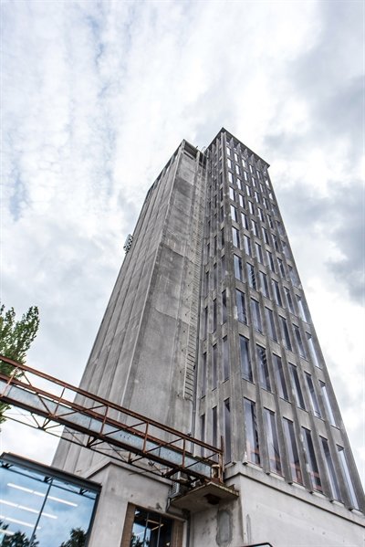 foto van de grijze silo die de lucht in steekt tussen de wolken