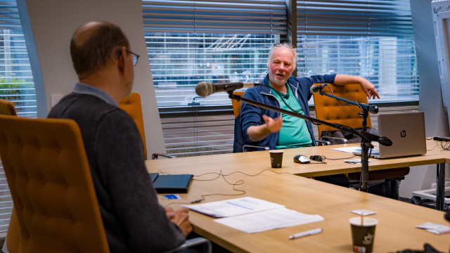 Henk van Dijk en Henk Esschendal in gesprek over dijkbewaking achter de microfoon voor de podcast