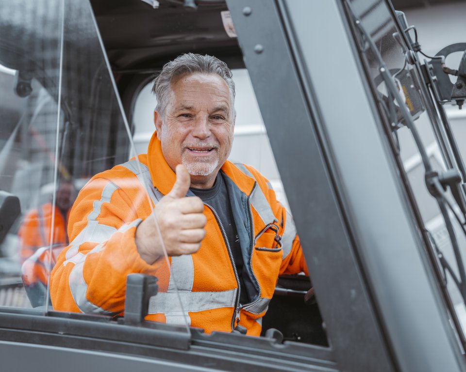 Buitendienst medewerker steekt zijn duim op