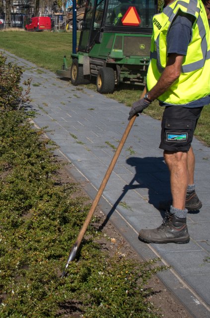 medewerker groenvoorziening bezig met het schoffellen van de aarde