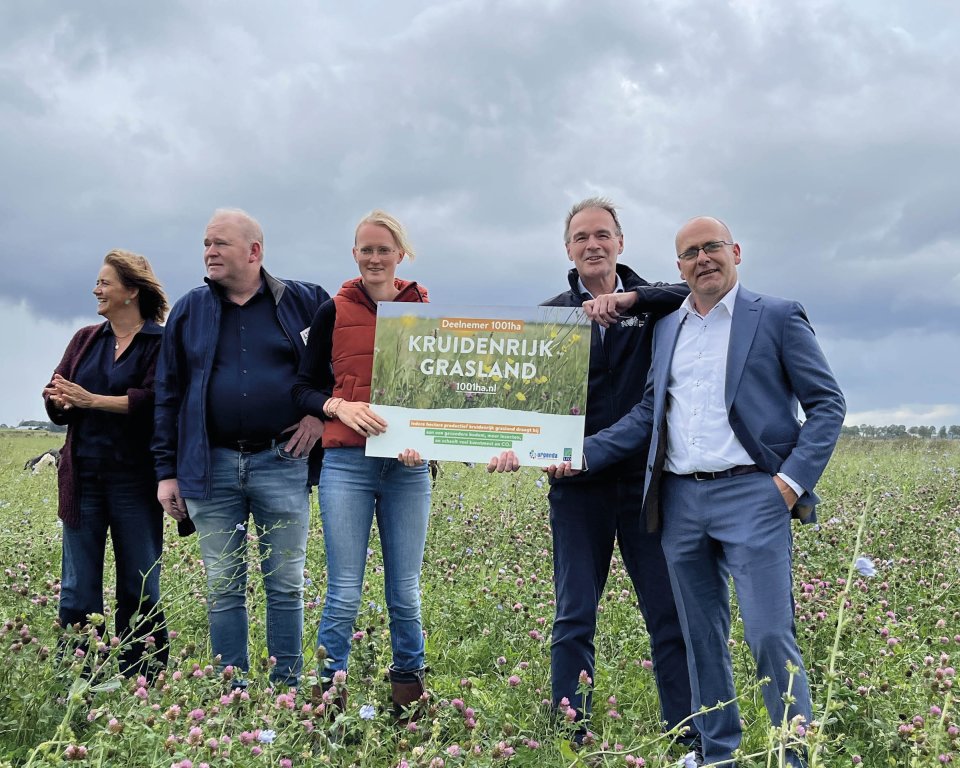 Vertegenwoordigers van Urgenda, LTO, de agrarische sector, de provincie en de gemeente bij het bord ‘Kruidenrijk grasland’.