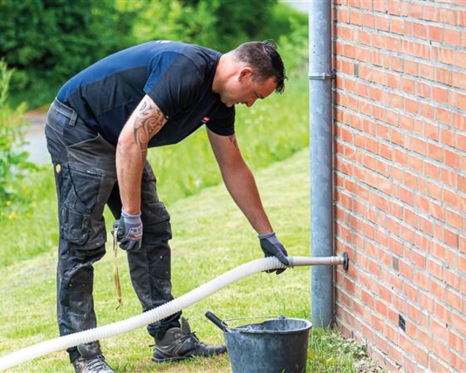 Man brengt spouwmuurisolatie aan in muur.