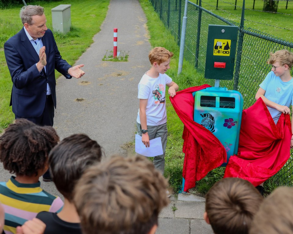 Gijs en Job van basisschool De Laak samen met Moris, de graffiti kunstenaar en wethouder Evert Jan Slootweg bij de onthulde prullenbak
